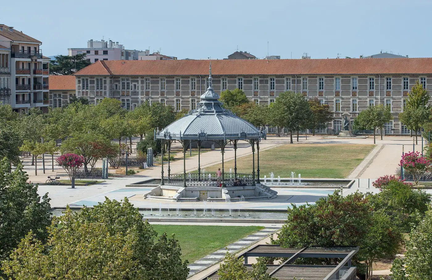 Le kiosque Peynet sur l'esplanade du Champ-de-Mars à Valence, entouré d'arbres et de jets d'eau